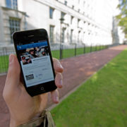 A serviceman accesses social media channels using a smart phone, outside MOD Main Building in London.